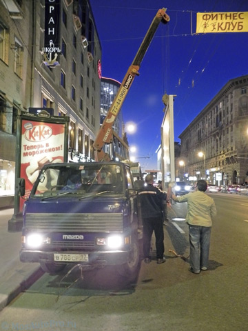 Разгрузка ПВХ рамы размером 3х2 метра манипулятором в центре Москвы на улице Тверская 17.