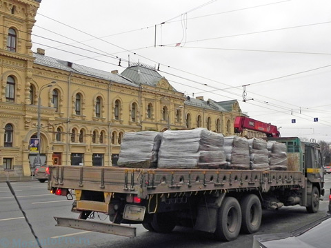 Перевозка рулонных газонов на поддонах манипулятором длинномером в центре Москвы.