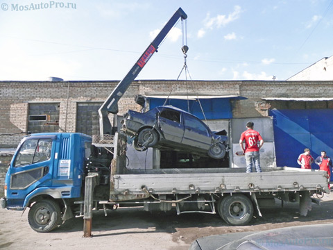 Погрузка разбитого легкового автомобиля Митсубиси Лансер на манипулятор-эвакуатор.
