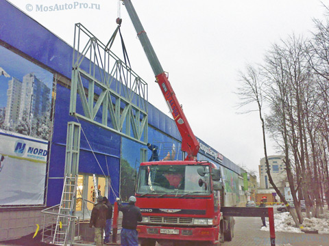 Монтаж уличной металлической рекламной конструкции размерами 4х7,6 метра с помощью крана манипулятора для магазина спортмастер.